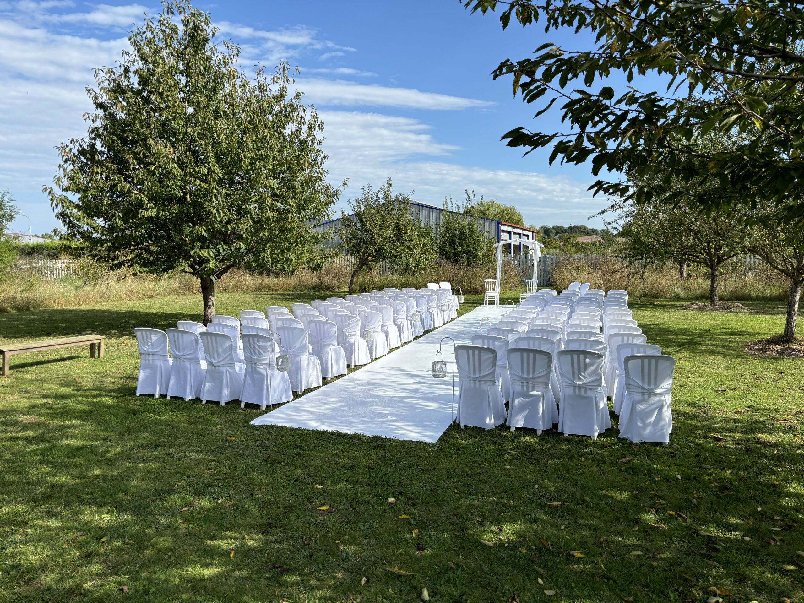 Location de mobilier pour cérémonie laïque. Chaise miami avec leur housses blanches, moquette blanche, chaise napoléon pour les mariés et une arche de cérémonie. Location Jani Event.